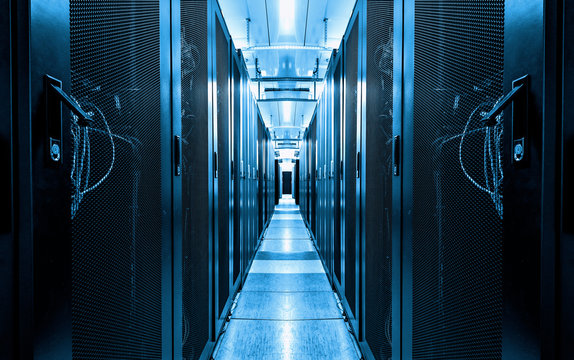 Dark blue data centre interior with rows of hardware equipment. Specialized building for hosting server and network equipment and connecting subscribers to Internet. Technology and cyberspace concept - Powered by Adobe