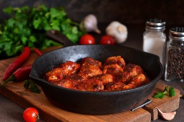 Meatballs in sweet and sour tomato sauce on the kitchen table. Top view