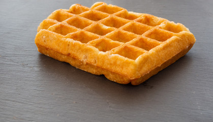 A Belgian waffle on a slate plate