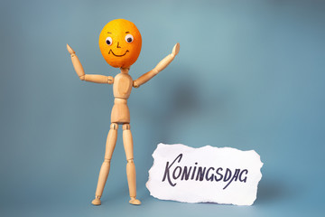 Wooden man with an orange head. Holland traditional festival Koningsdag Kings day.