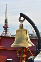 Ship bell against the background of port cranes. Kaliningrad