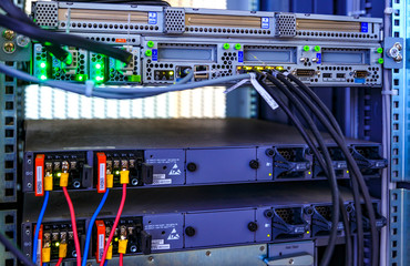 Naklejka premium Blade panel, switch, cable, LED lamps in data center. Communication and internet network server room. Close up fiber optic wires, installed in rack