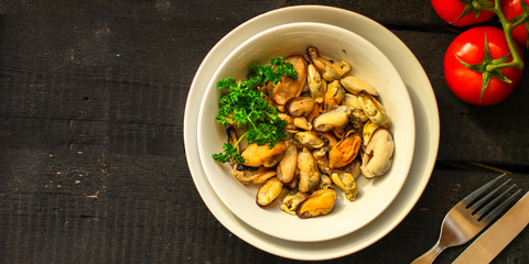 mussels A serving of seafood is a white plate. food background. top image