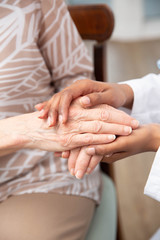 Woman of color Comforting Elderly Caucasian Hands at a Nursing Home or Elderly Care