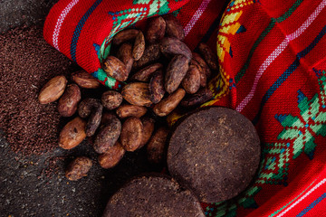 Cocoa, mexican chocolate and cacao powder on a traditional metate, used to extract the powder from...