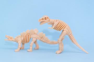 Plastic toy animal dinosaur skeleton on blue background.