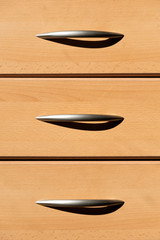 Plain wooden drawers with metal handles and shadow for office, home, bedroom, study