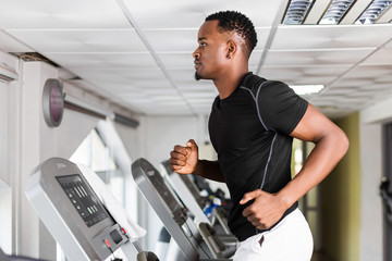 Black African American  young man doing cardio workout at the gym