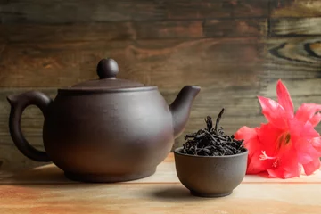 Foto op Aluminium Set for tea ceremony. Large clay  teapot, cup with fresh green tea and red flower. Front view. Copy space, space for text © Nataliia