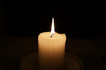 Lighted single Candle. Selective focus of candle. Candle fire. Candle on a dark background