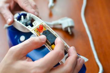 Hands repair iron. Concept: home appliance repair, repair services, home master.