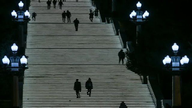 People walk in the evening on the glowing stairs. Close up.