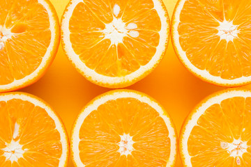 Cut halves of juicy orange on yellow background. Orange fruit, citrus minimal concept. Creative summer food minimalistic background. Top view, flat lay