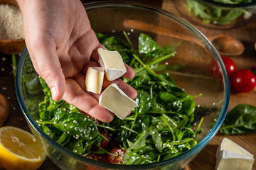 Salad with cheese on background with ingredients.