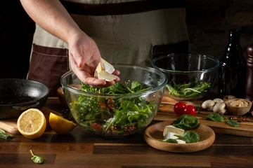 Foto op Canvas Cooking diet salad with flying fresh vegetables by chef hands on background with ingredients. © Anton