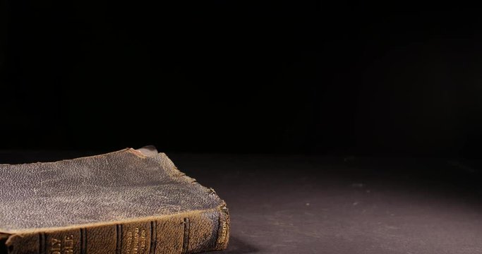 Old worn vintage Holy Bible toppling over