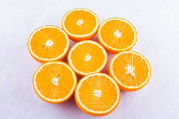 Sliced oranges fruit on white background. Citrus for making juice. Halved oranges creatively stacked on table. Background of oranges. Top view