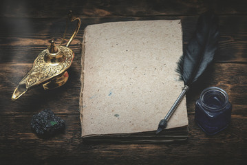 A Wish list mock up, quill pen and a golden magic lamp on a wooden board background. Fulfillment of...