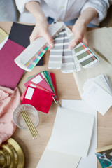 Fototapeta na wymiar Woman at workplace choosing colourful paper charts