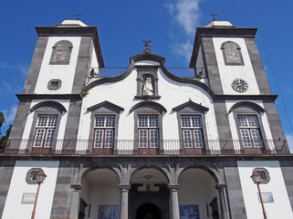 front view of the historic Church of Our Lady of Monte - Igreja de Nossa Senhora do Monte in funchal in bright sunlight with blue sky