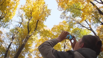 Tourist Photographing Autumn Leaves in Ukrainian Nature Park