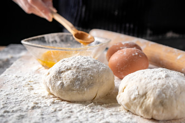 White flour with eggs, butter and dough on a cooking board