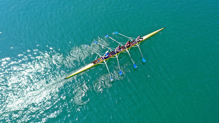 Aerial drone bird's eye view photo of yellow sport canoe operated by team of young team in emerald...