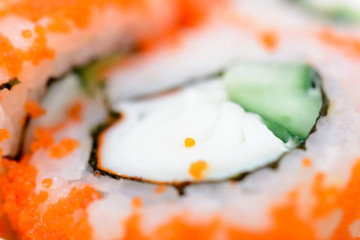 Macrophoto of the sushi rolls japanese food isolated. California Sushi roll with tuna, vegetables, caviar tobica, cucumber and wasabi close-up. Japan restaurant menu.