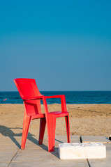 red plastic chair on beach of Lido di Spina, Italy