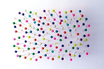 Sewing pins. Colorful sewing pins background. Close Up of sewing pins with multi colored heads....