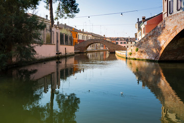 canal, bridge and colorful houses in Comacchio, Italy