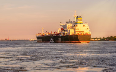 A big ship is traveling at Mississippi River under sunset