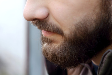 Profile portrait of brutal adult working  man after labor day  with a beard close up 