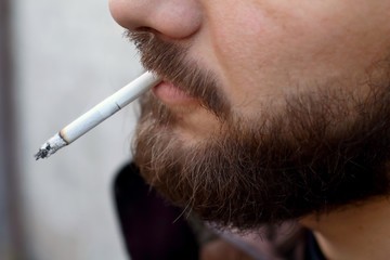 Portrait of brutal adult working  man after labor day  with a beard close up smoking  cigarette,...