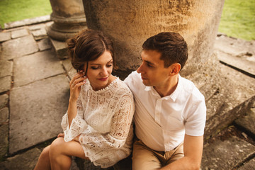 A wonderful love story. Young couple walking around the old architectural columns