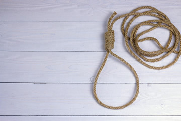 Hanging noose. Rope with loop. Rope with knot and loop on white wooden background.