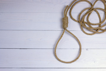 Obraz premium Hanging noose. Rope with loop. Rope with knot and loop on white wooden background.