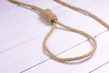 Obraz premium Hanging noose. Rope with loop. Rope with knot and loop on white wooden background.