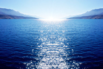 Abstract blue big dimension background with sea, sky and with white sun which enters the sea and...