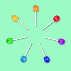 Set of colorful lollipops grouped in a circle isolated on green background.