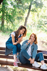 Fototapeta na wymiar Two beautiful young woman resting on a bench