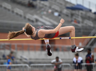 Young girls jumping high for a high jump track meet