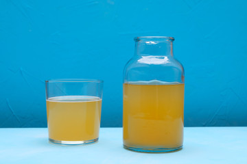 Fermented kombucha tea in a jar on blue background. Detox drink.