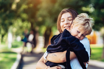 Fototapeta premium Beautiful young mother holds on hand her little son