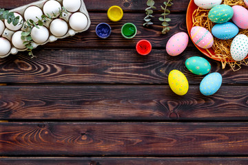 eggs with colorful paint for easter tradition on wooden background top view mockup