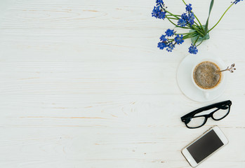workplace. Coffee, glasses and a phone on a wooden background