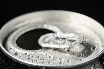 aluminum soda can neck with ring close-up covered with water drops