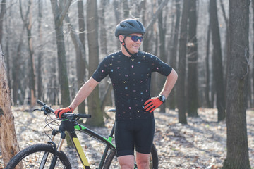 male athlete mountainbiker with bicycle along a forest trail. in forest mist