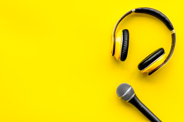 blogger, journalist or musician work space with microphone and headphones on yellow background top...