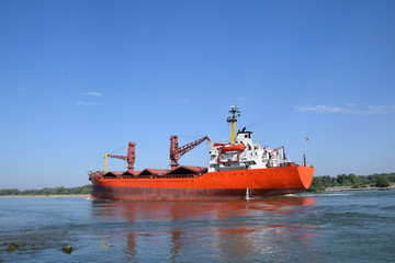 Fototapeta premium Cargo ship (bulk carrier) floats on the Danube river. Sulina, Danube Delta, Romania.